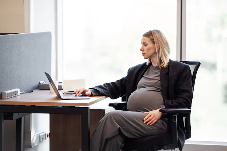 Femme enceinte assise à son bureau