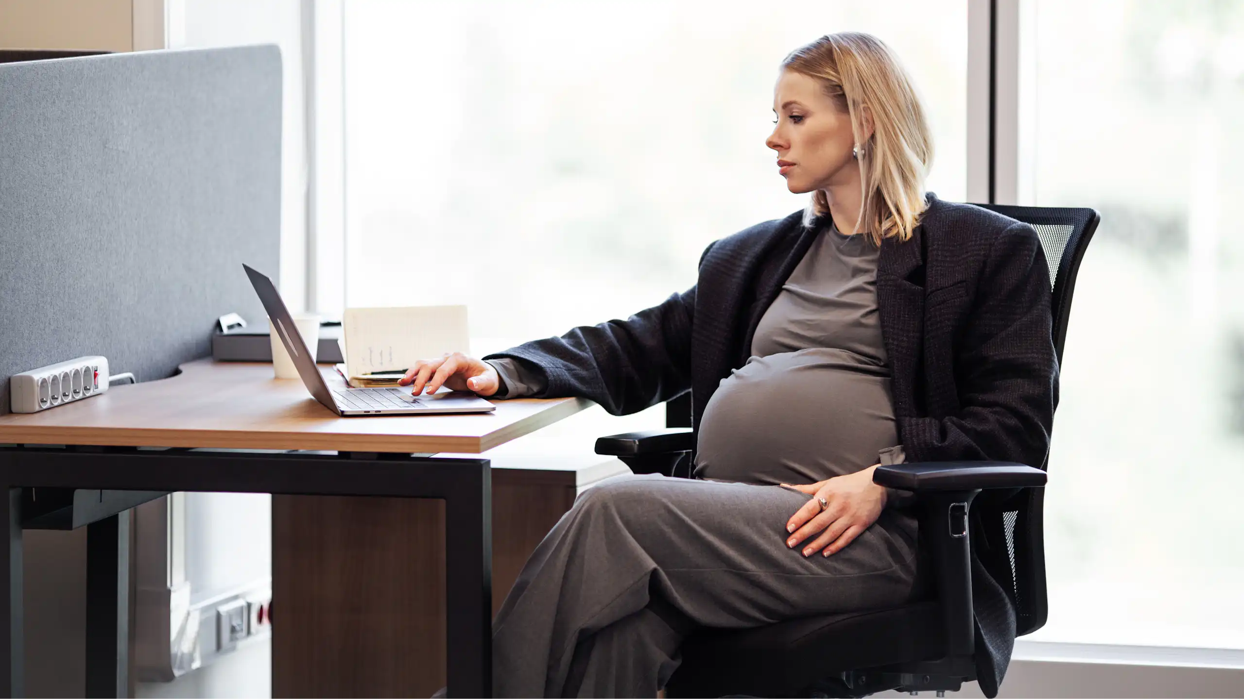 Femme enceinte assise à son bureau