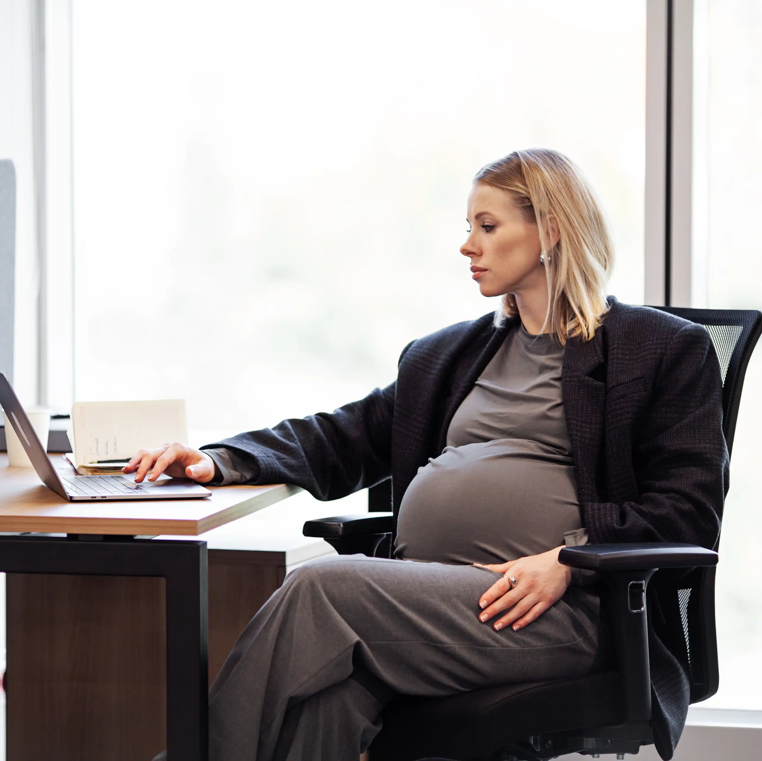 Femme enceinte assise à son bureau