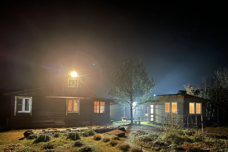 A very lit building in the countryside.
