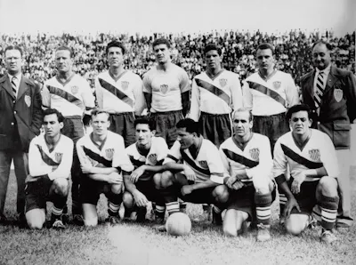 A black and white photo shows a group of men in soccer jerseys.