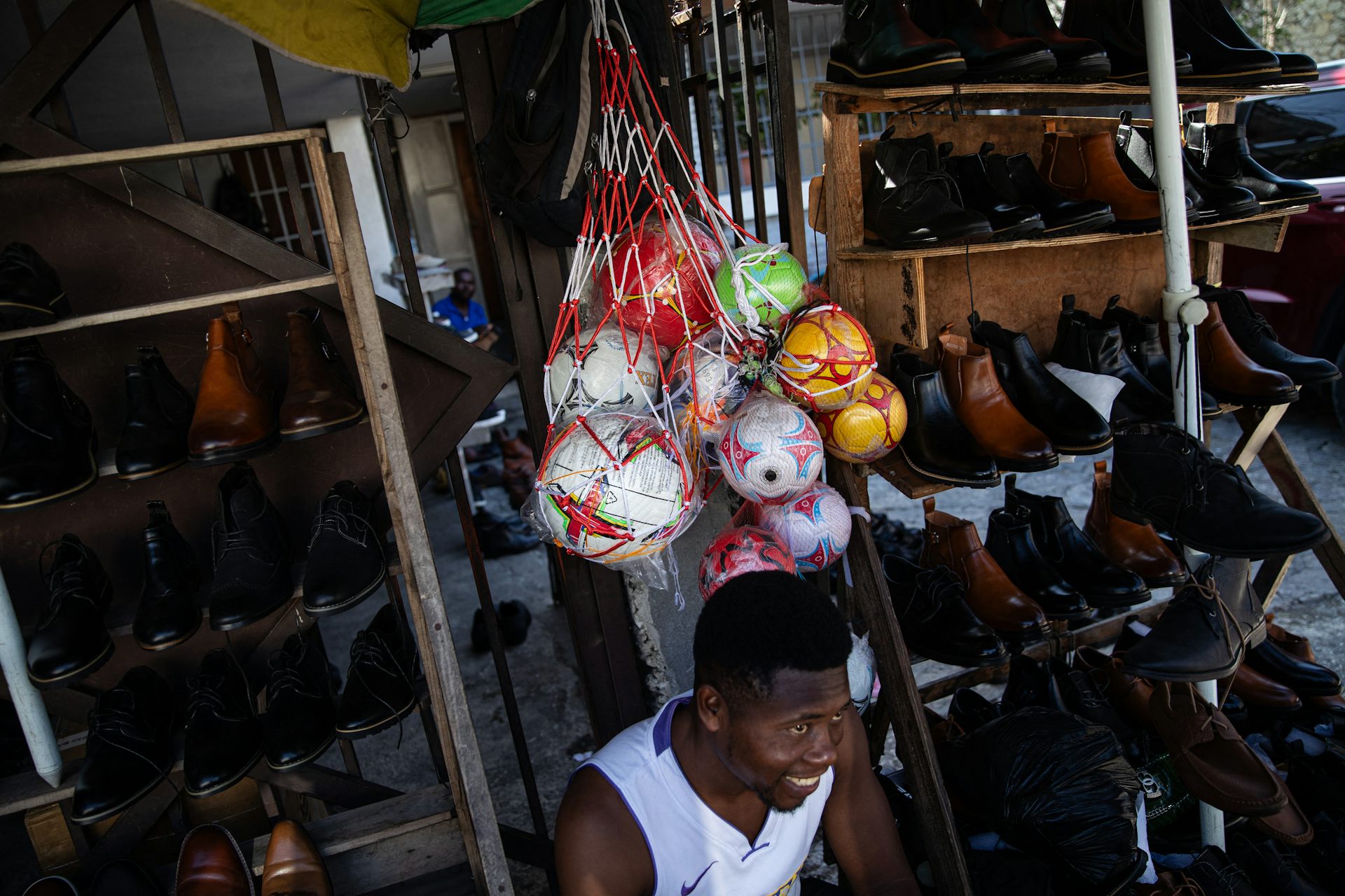A man sits ion front of a bag of balls.