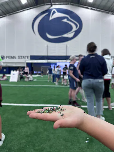 A hand holding tiny colored beads.