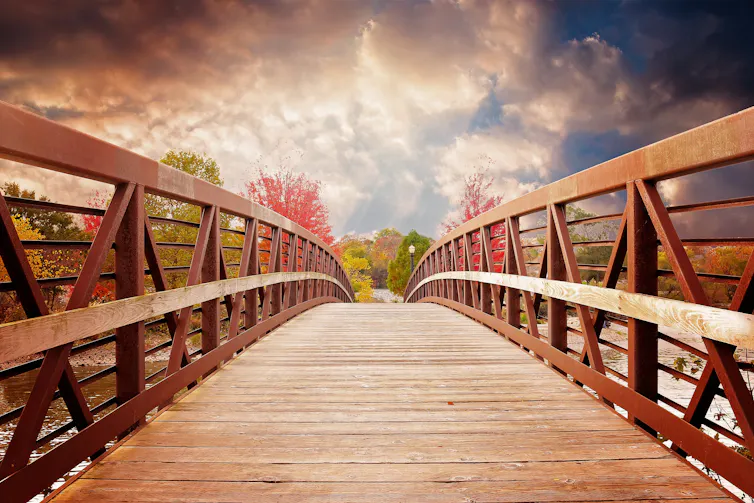 Une passerelle en bois avec un paysage en arrière-plan