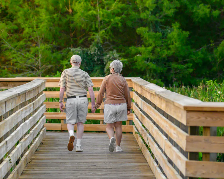 A senior couple walking along a boardwalk