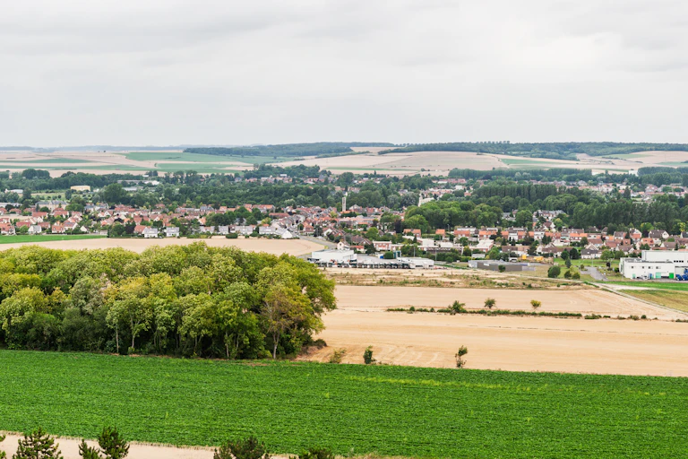 Vue panoramique d'un paysage rural avec un village en arrière-plan.