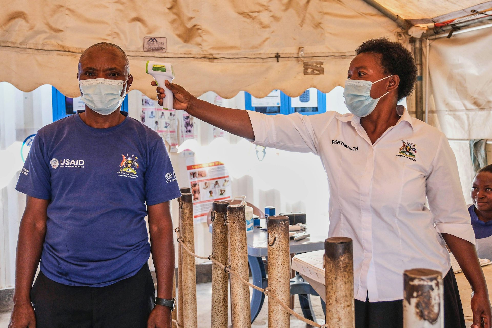 A health worker checks a man's temperature at a temporary health clinic at the Mpondwe border crossing linking Uganda and the Democratic Republic of the Congo, June 4, 2026.