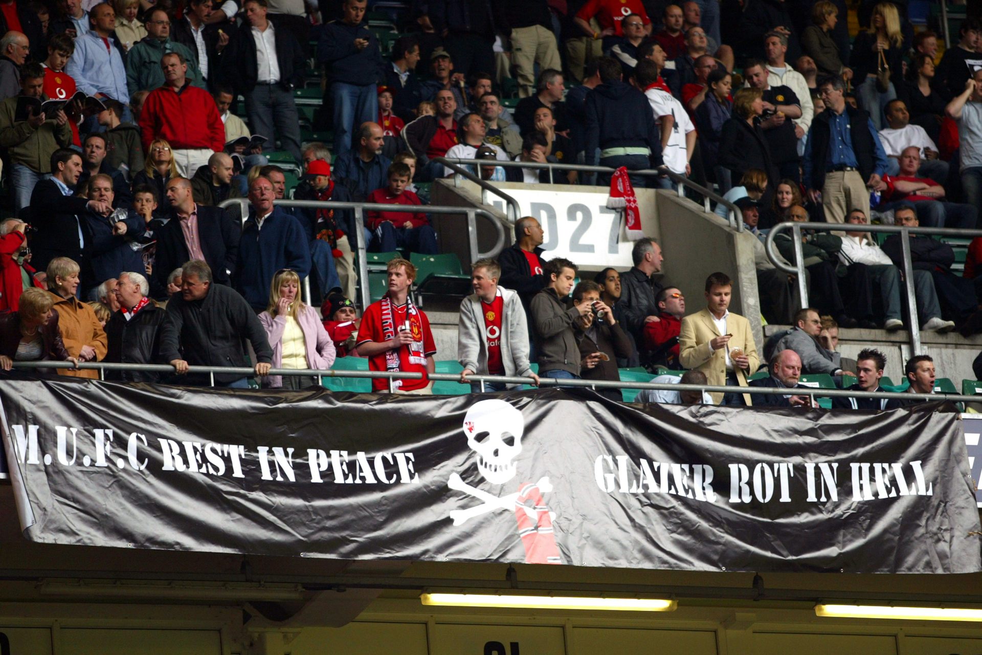 A large banner is seens saying 'MUFC Rest in Peace. Glazer rot in hell.