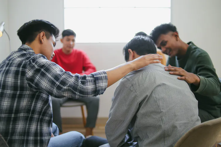 Regardless of poisonous popularity, our analysis presentations podcasts can assist males’s psychological well being 1 A group of young men sitting in a circle talking, one comforting another