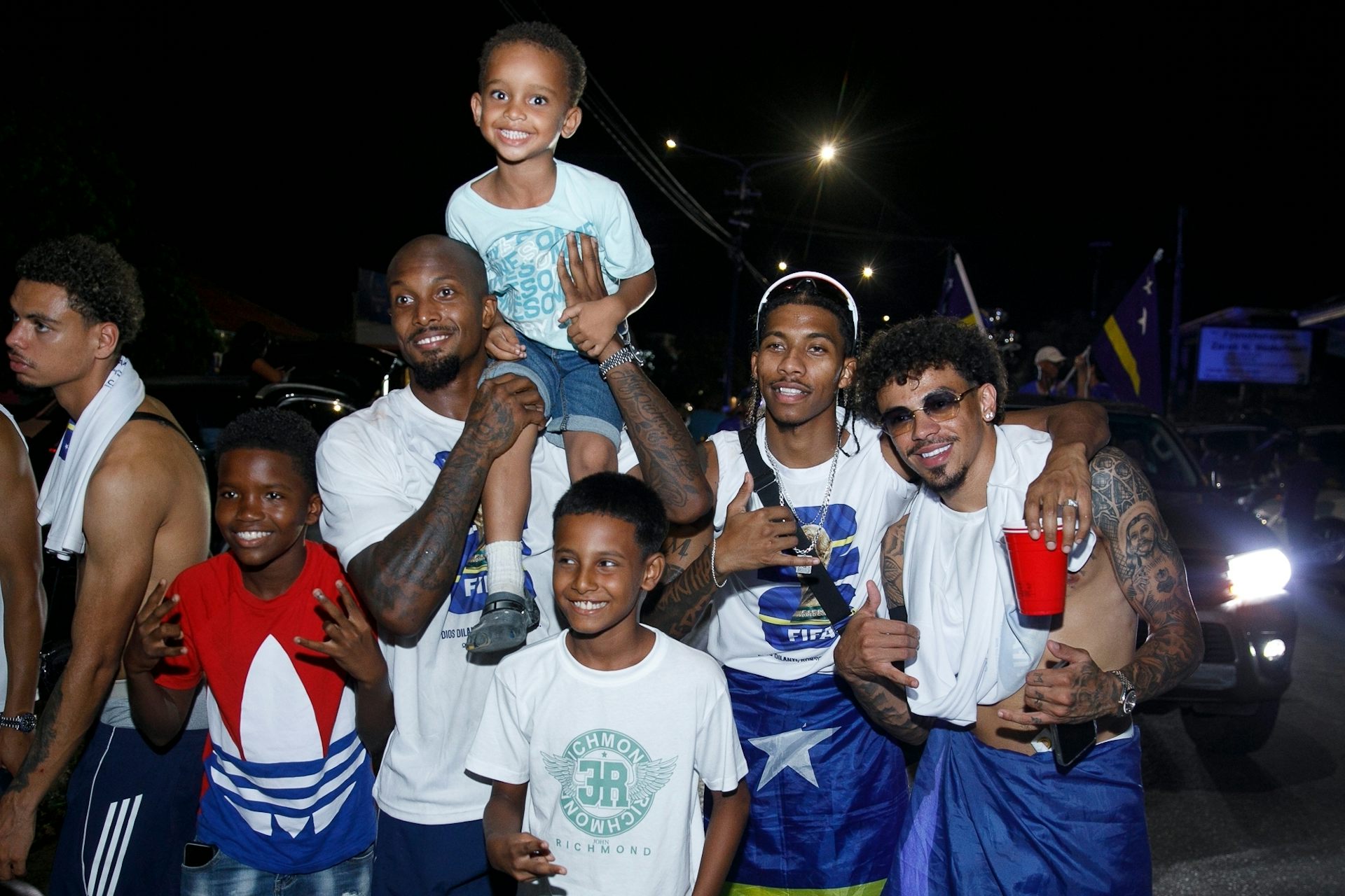 Un grupo de hombres y niños posan para una foto y sonríen.