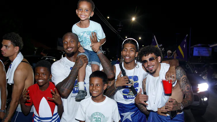 Un grupo de hombres y niños posan para una foto y sonríen.