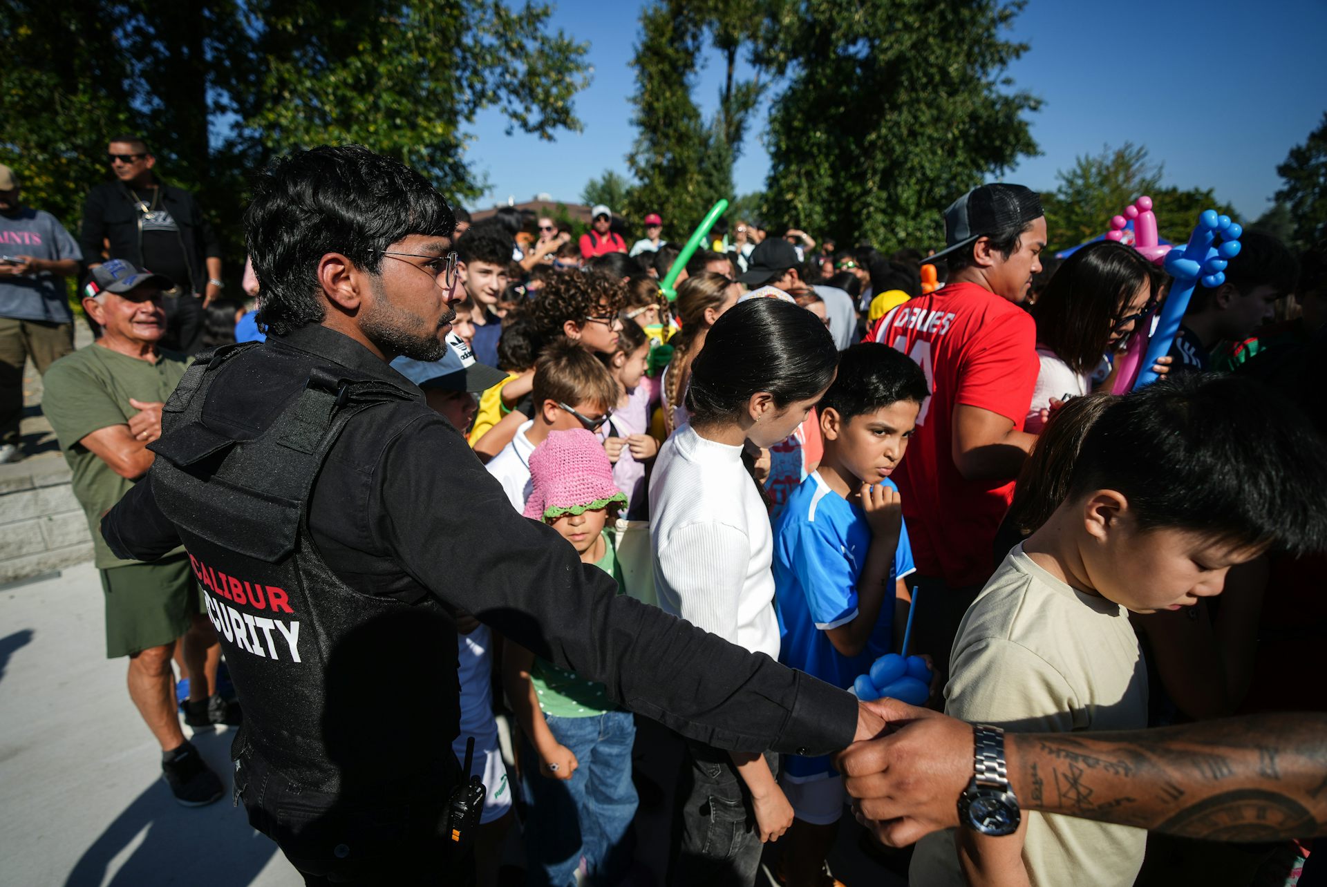 seguridad y un grupo de niños parados al aire libre.