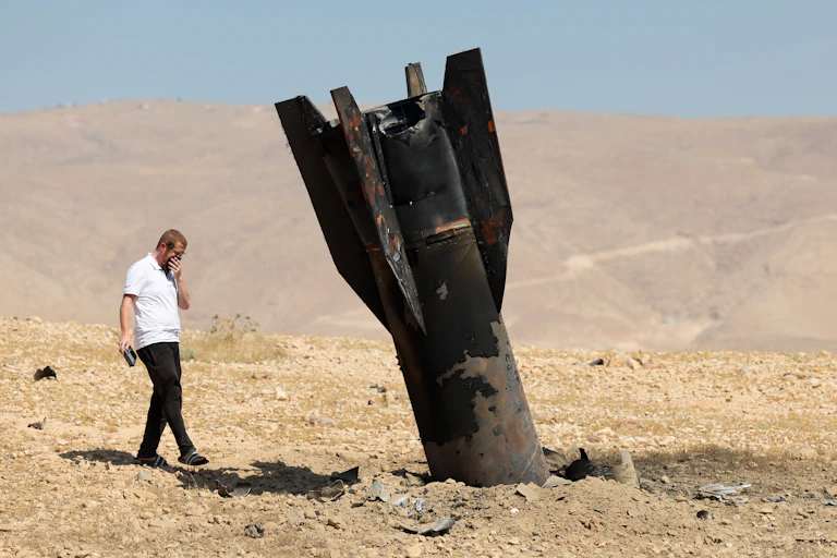 An Israeli man looks at the remains of an Iranian ballistic missile.