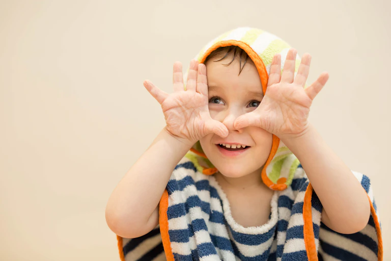 A child show their wrinkly fingers after being in water.