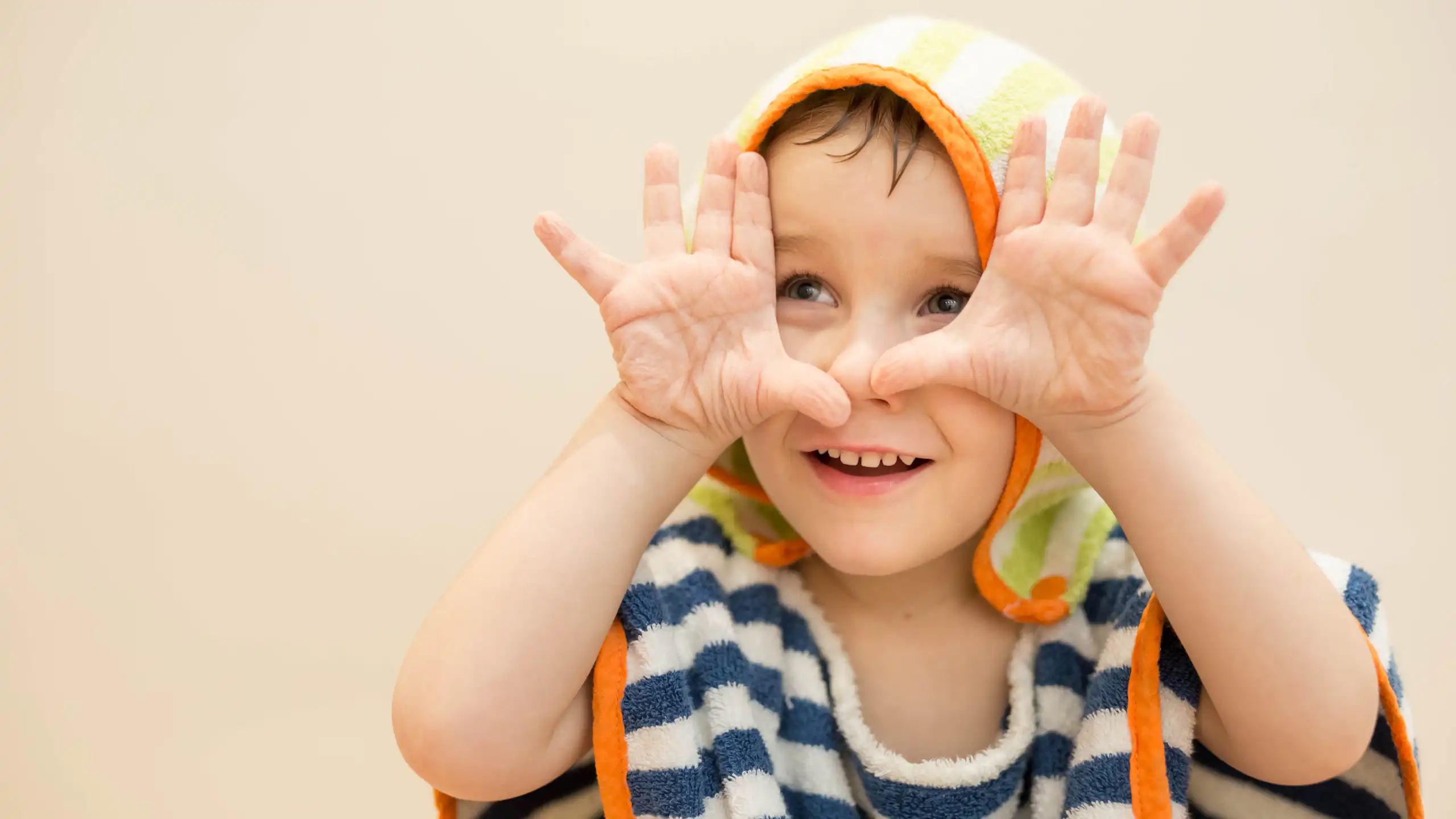 A child show their wrinkly fingers after being in water.