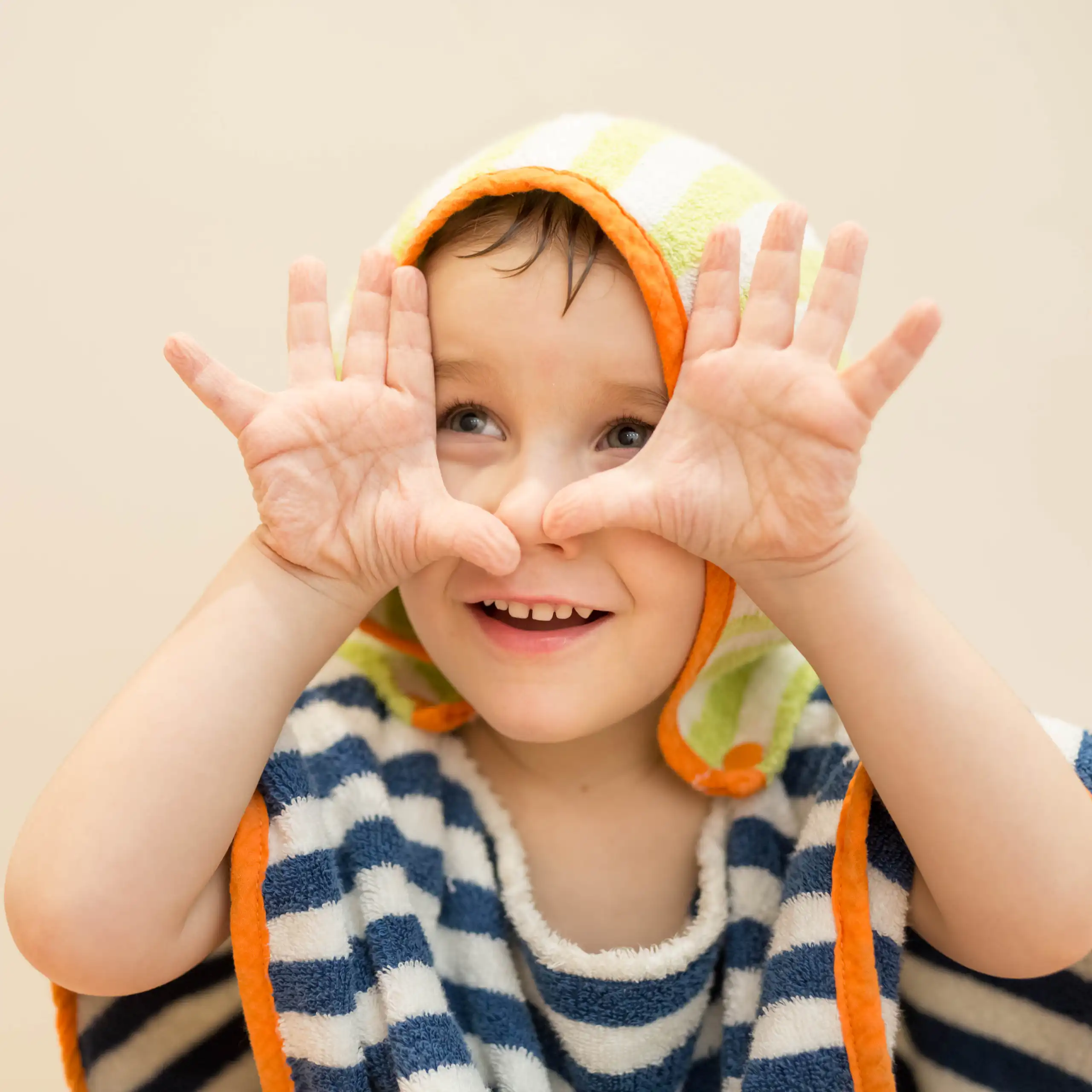 A child show their wrinkly fingers after being in water.