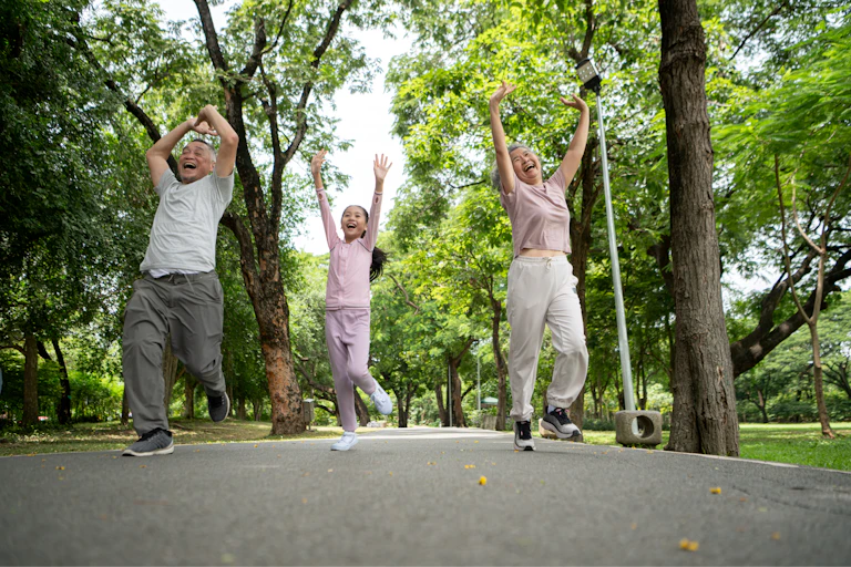 Happy grandparents and grandchild running joyfully together in a park