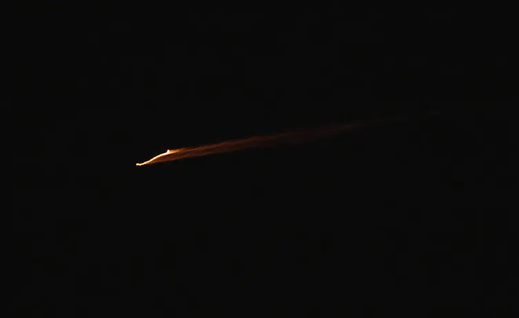A missile crosses the night sky over the West Bank city of Nablus.
