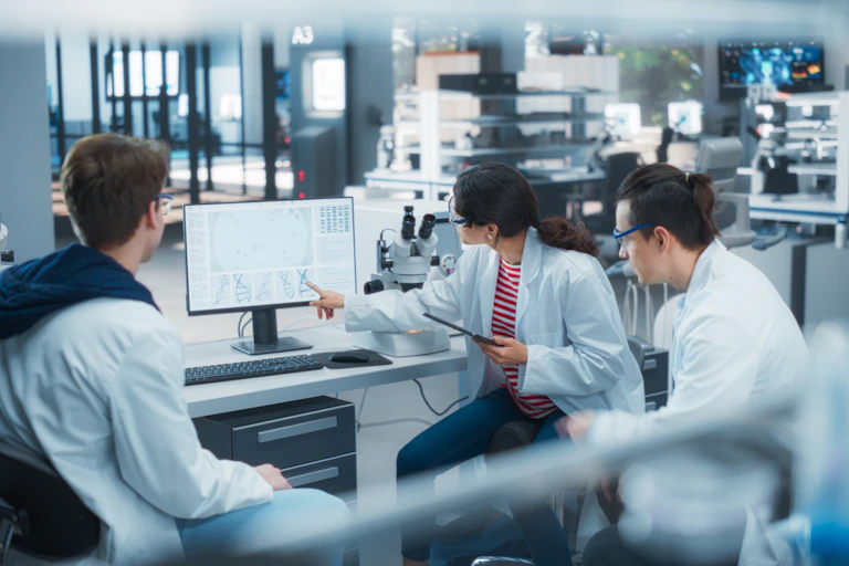 Stock image of scientists looking at a computer screen.