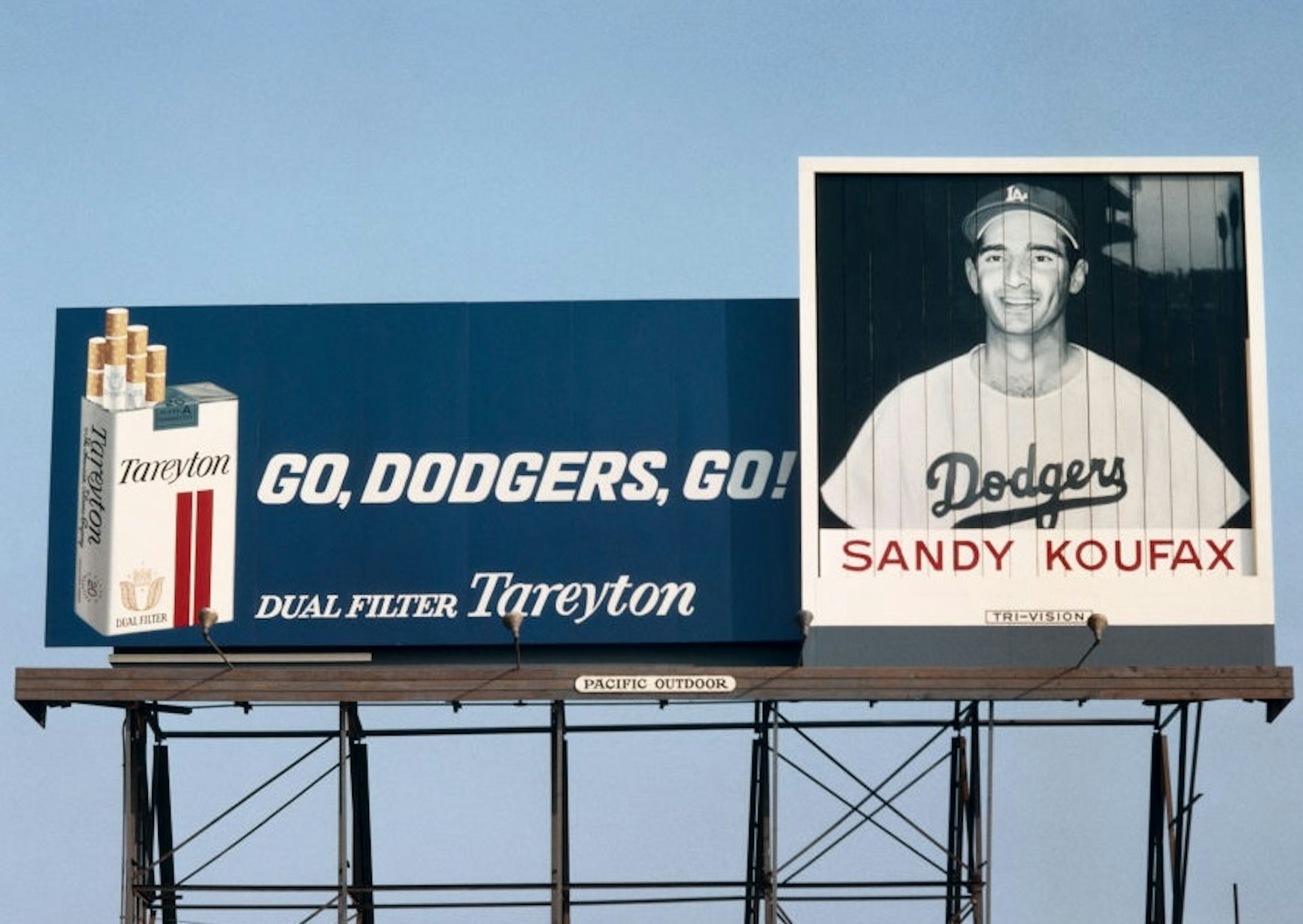 Black-and-white photo of smiling man in baseball uniform next to an image of a box of cigarettes and the text 'Go, Dodgers, Go!'