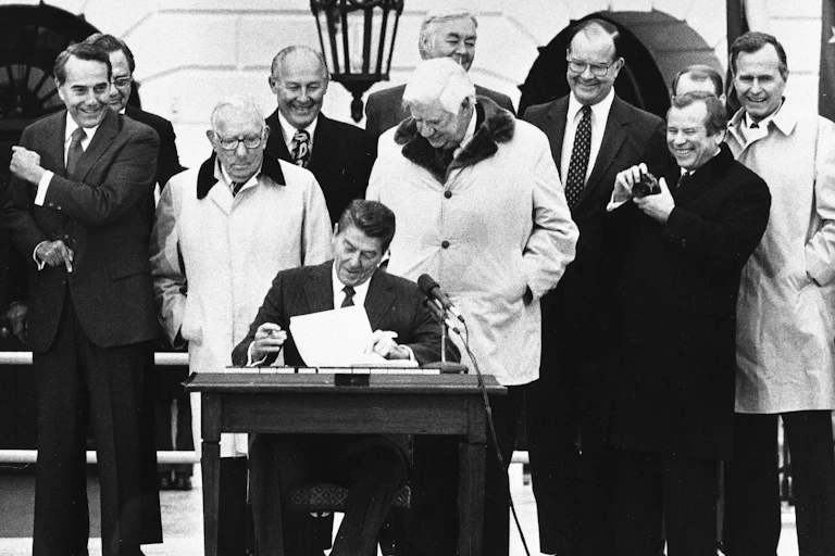 In a 1983 photo, President Ronald Reagan is flanked by congressional leaders on the White House South Lawn as he signs the Social Security reform bill.