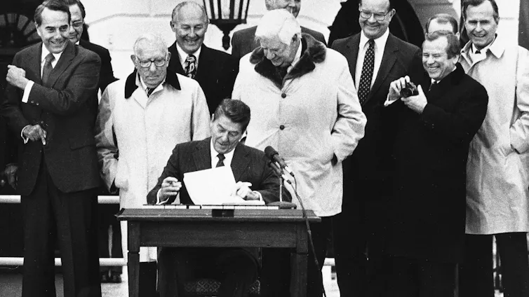 In a 1983 photo, President Ronald Reagan is flanked by congressional leaders on the White House South Lawn as he signs the Social Security reform bill.