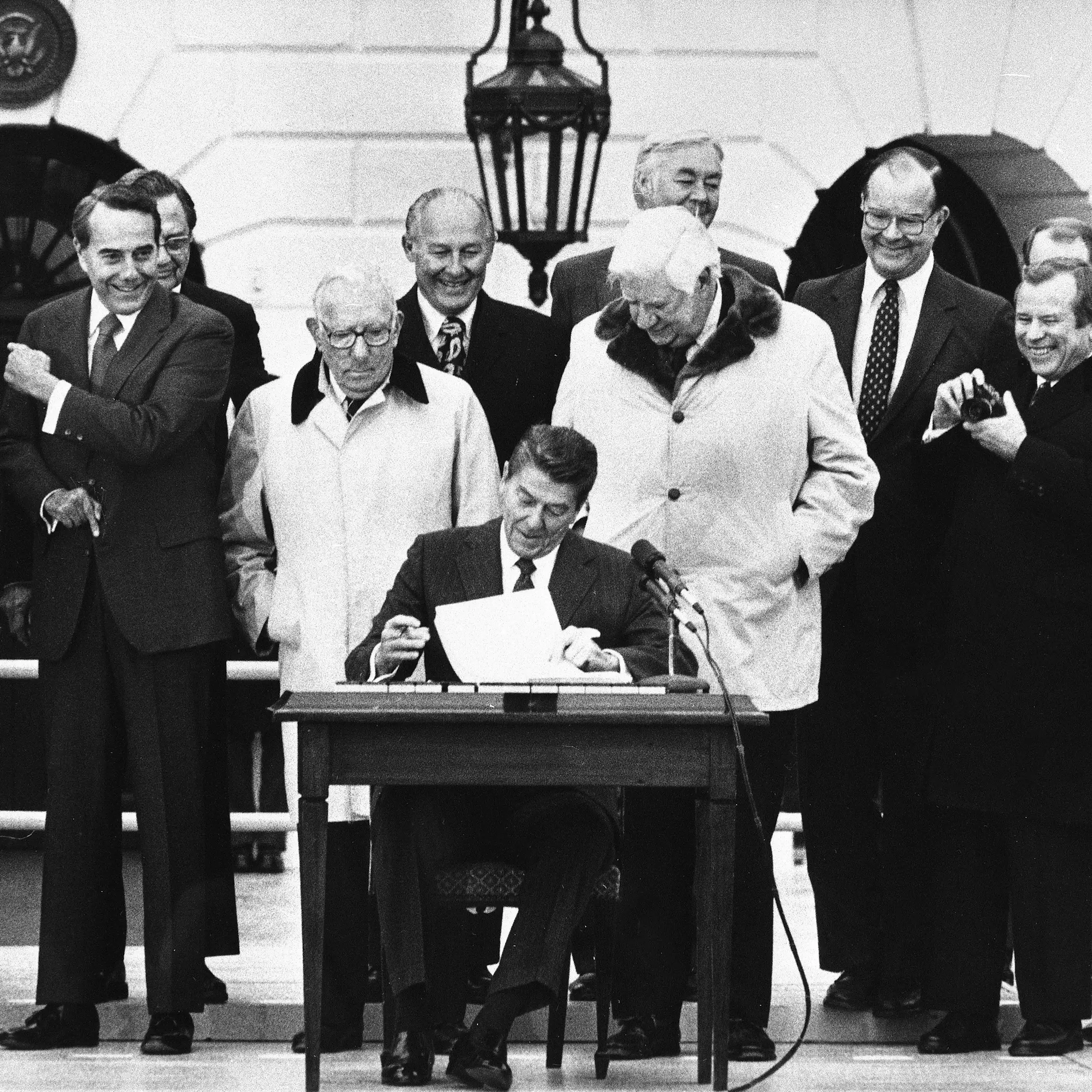 In a 1983 photo, President Ronald Reagan is flanked by congressional leaders on the White House South Lawn as he signs the Social Security reform bill.