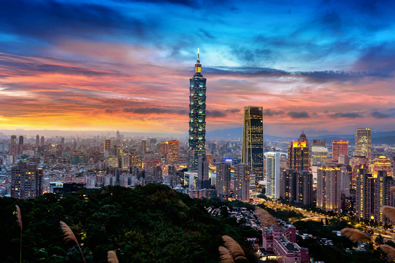 a city skyline with tall glass buildings at sunset