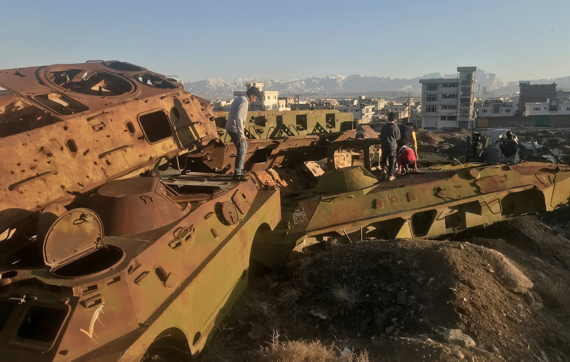 Afghan children playing on the wreckage of Soviet tanks in the outskirts of Kabul.