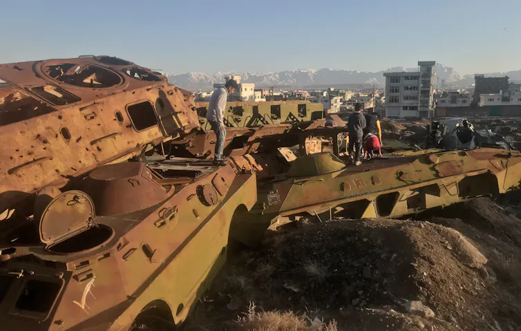 Afghan children playing on the wreckage of Soviet tanks in the outskirts of Kabul.