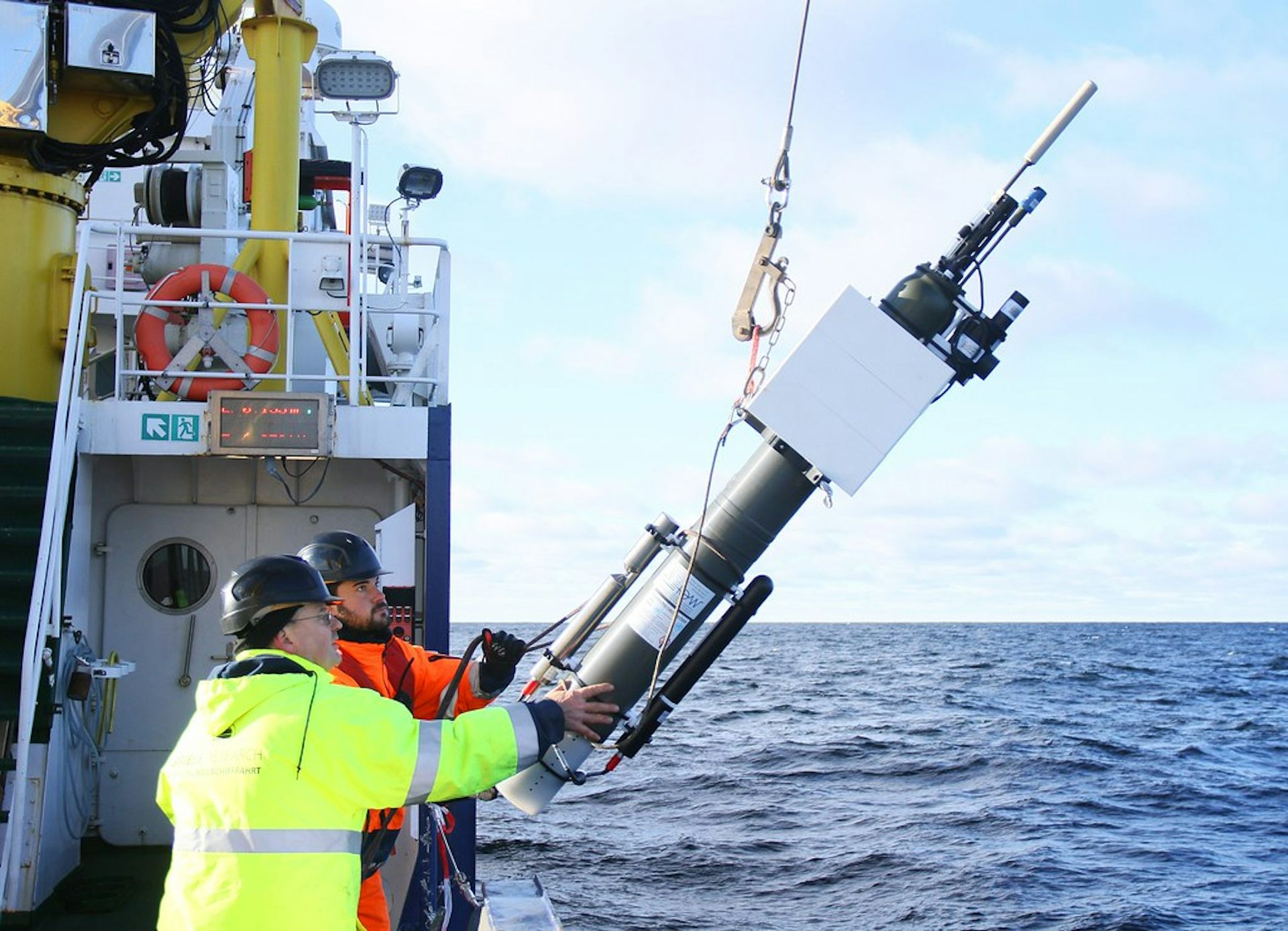 Deux scientifiques en pleine mer mettant à l'eau une balise Argo.