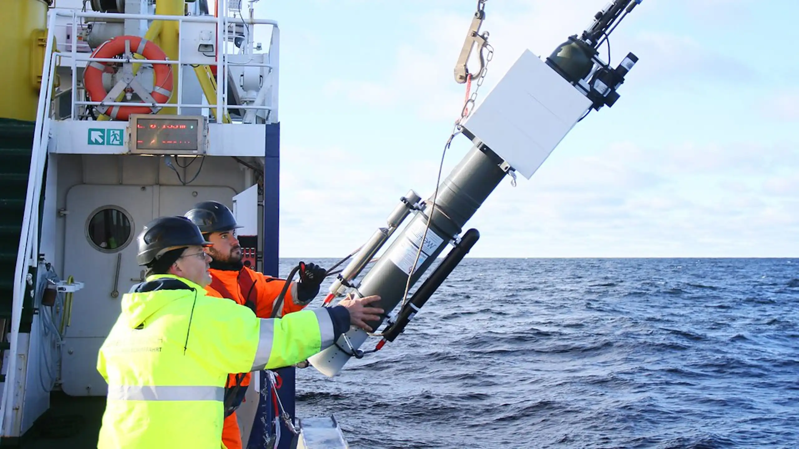 Deux scientifiques en pleine mer mettant à l'eau une balise Argo.