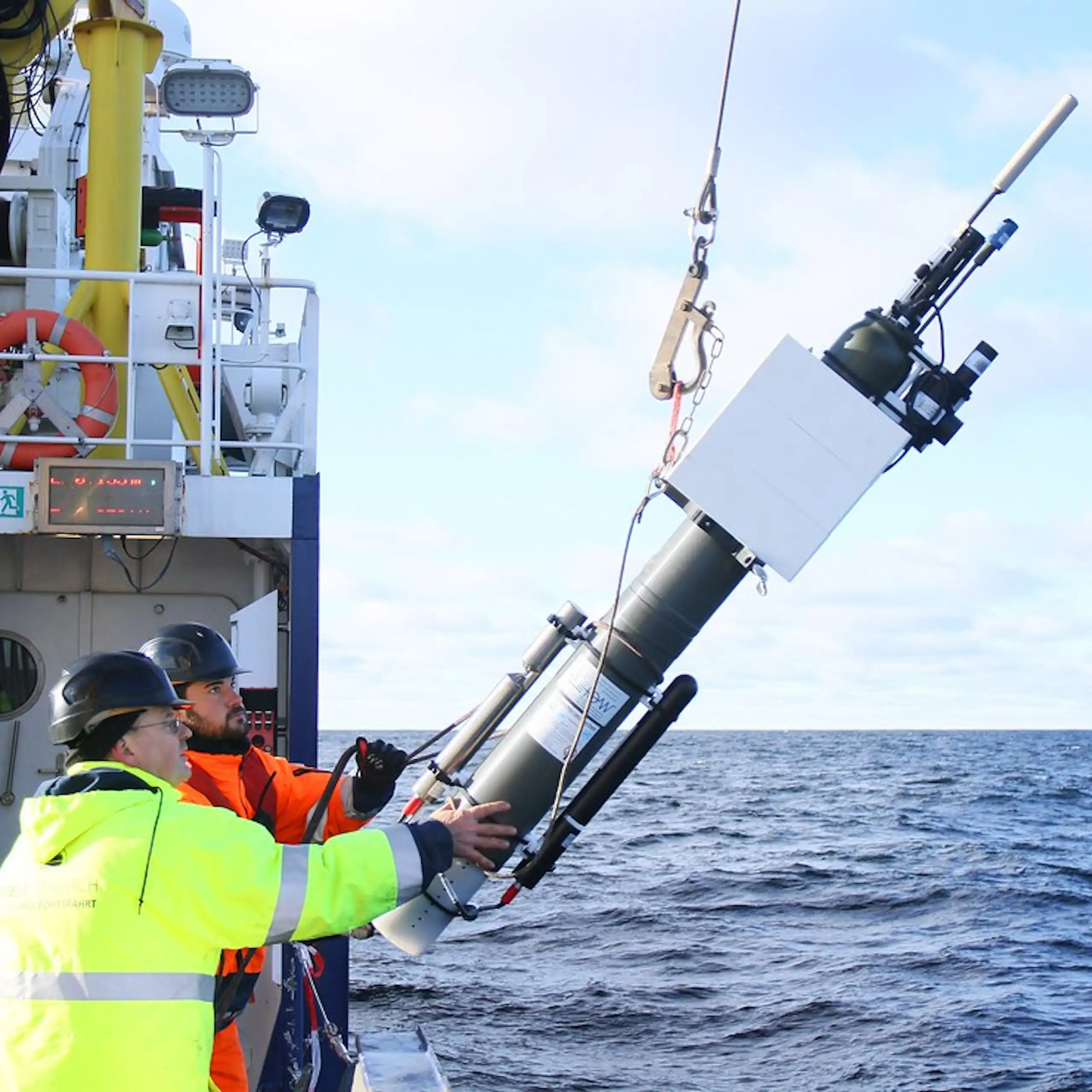 Deux scientifiques en pleine mer mettant à l'eau une balise Argo.