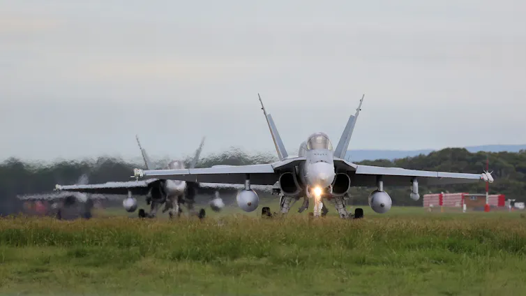 fighter planes about to take off from runway.