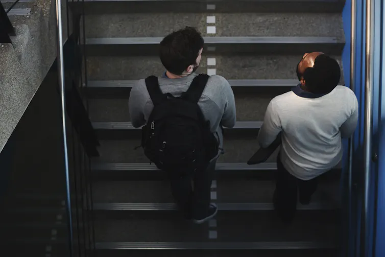 Two teen boys walking up school stairs