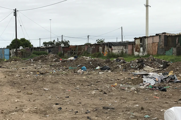 Shacks in the background of an area of open land