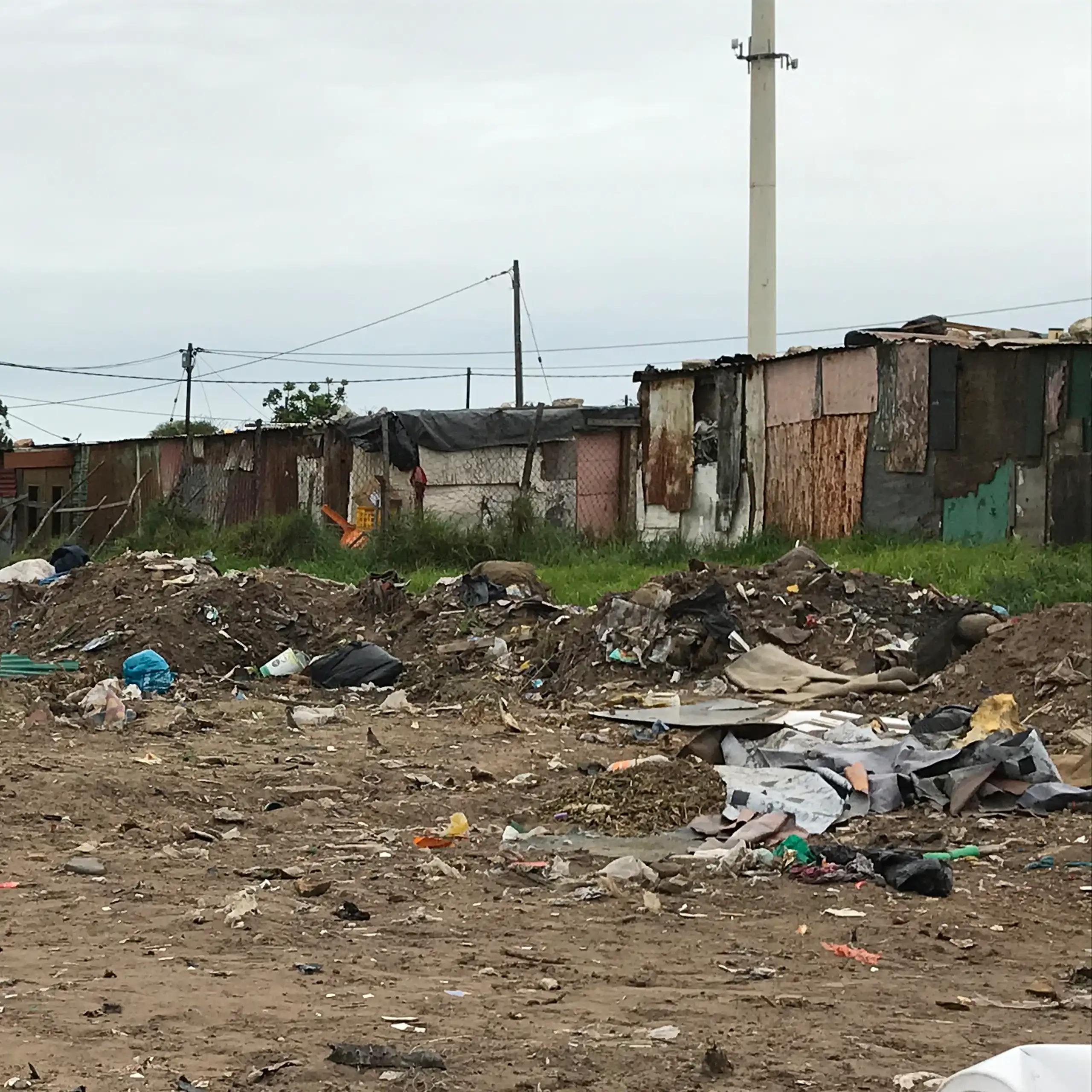 Shacks in the background of an area of open land