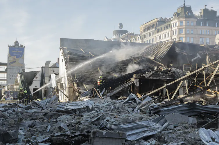 Ukrainian rescuers work at the site of a Russian strike on a car dealership in Kyiv.