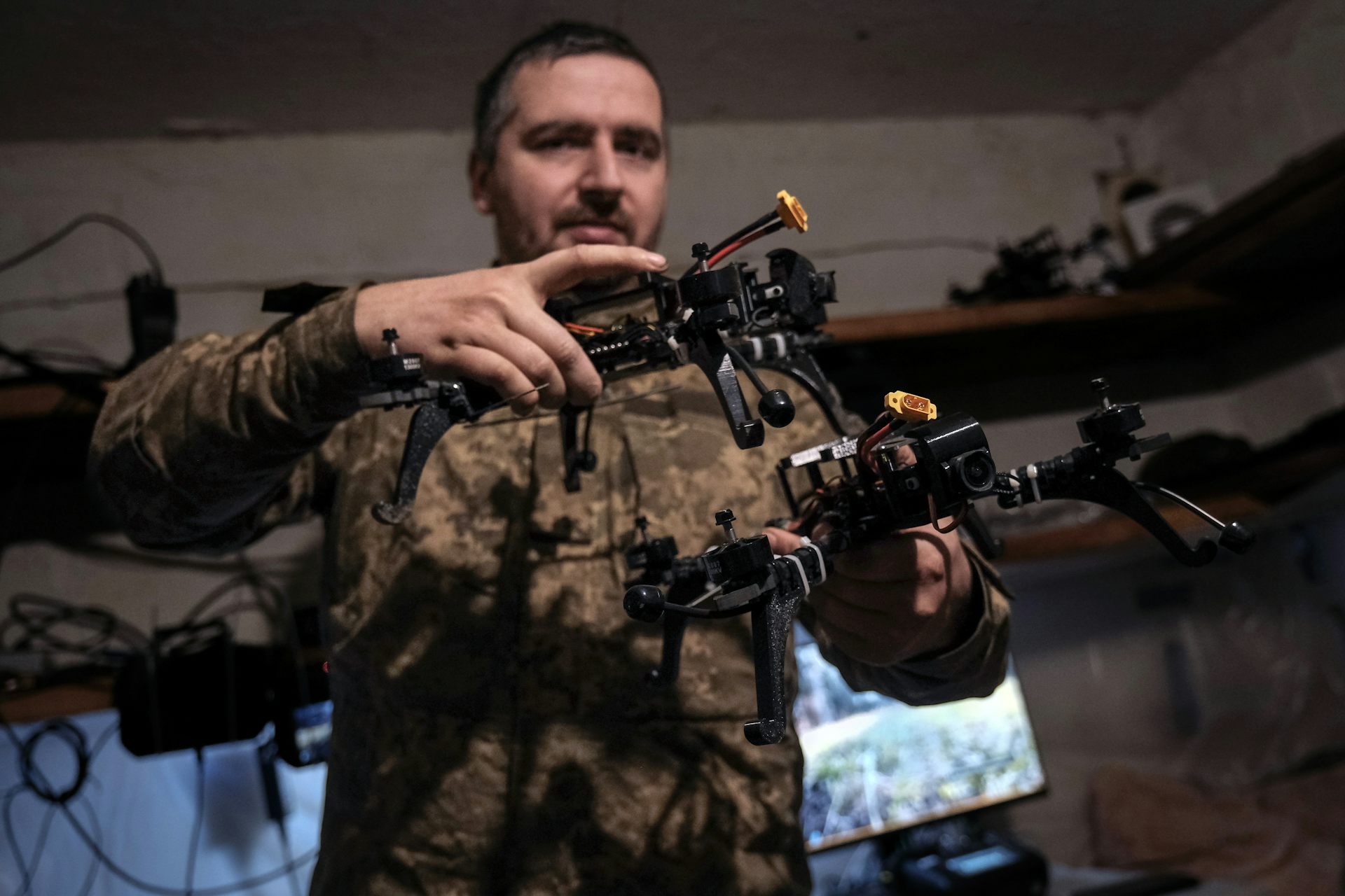 A Ukrainian drone pilot holds a first-person view drone at an undisclosed location near the frontline.