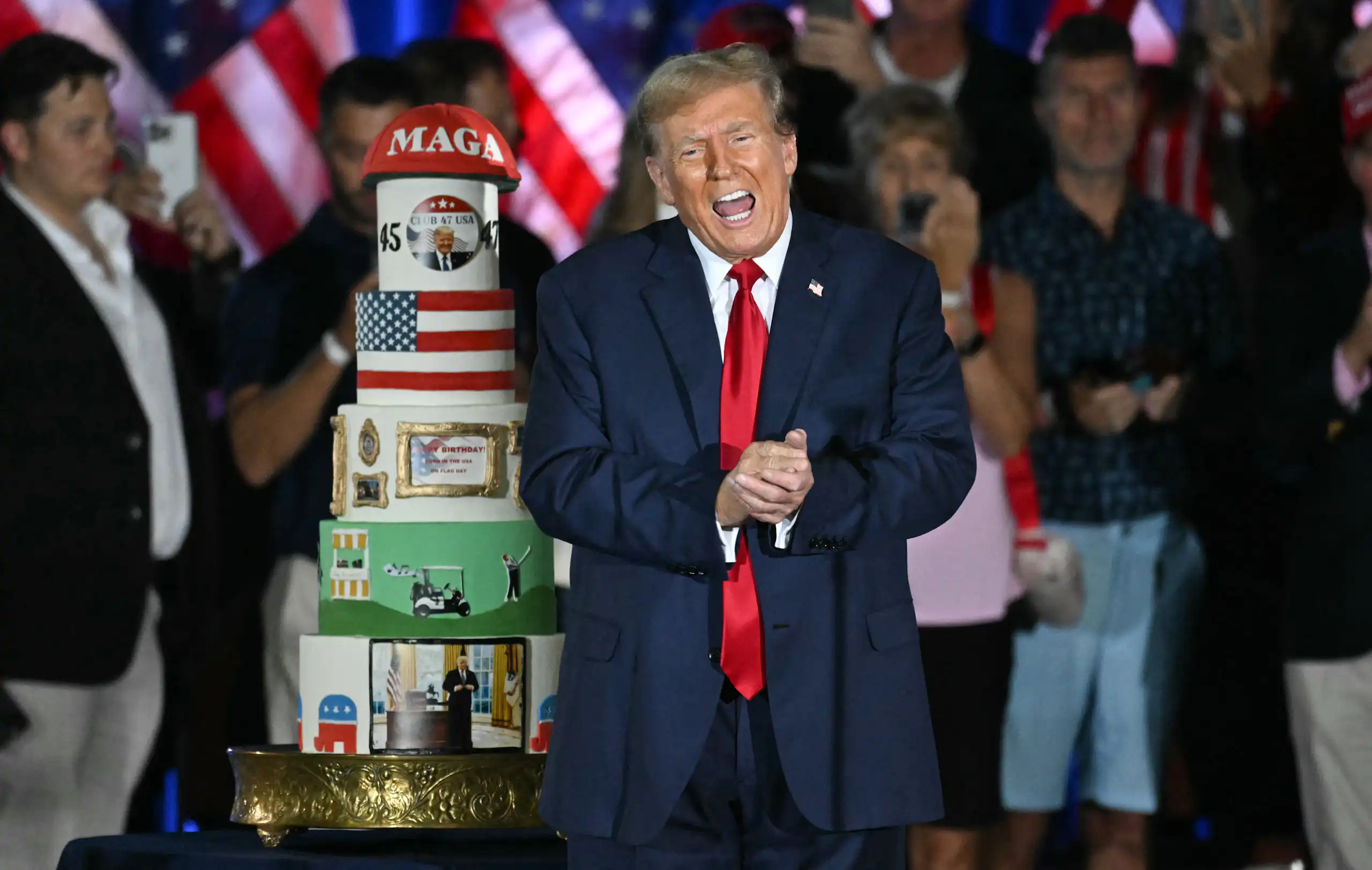 Portrait de Trump à côté de son gâteau couvert de photos de lui, du drapeau américain et d'une casquette MAGA.