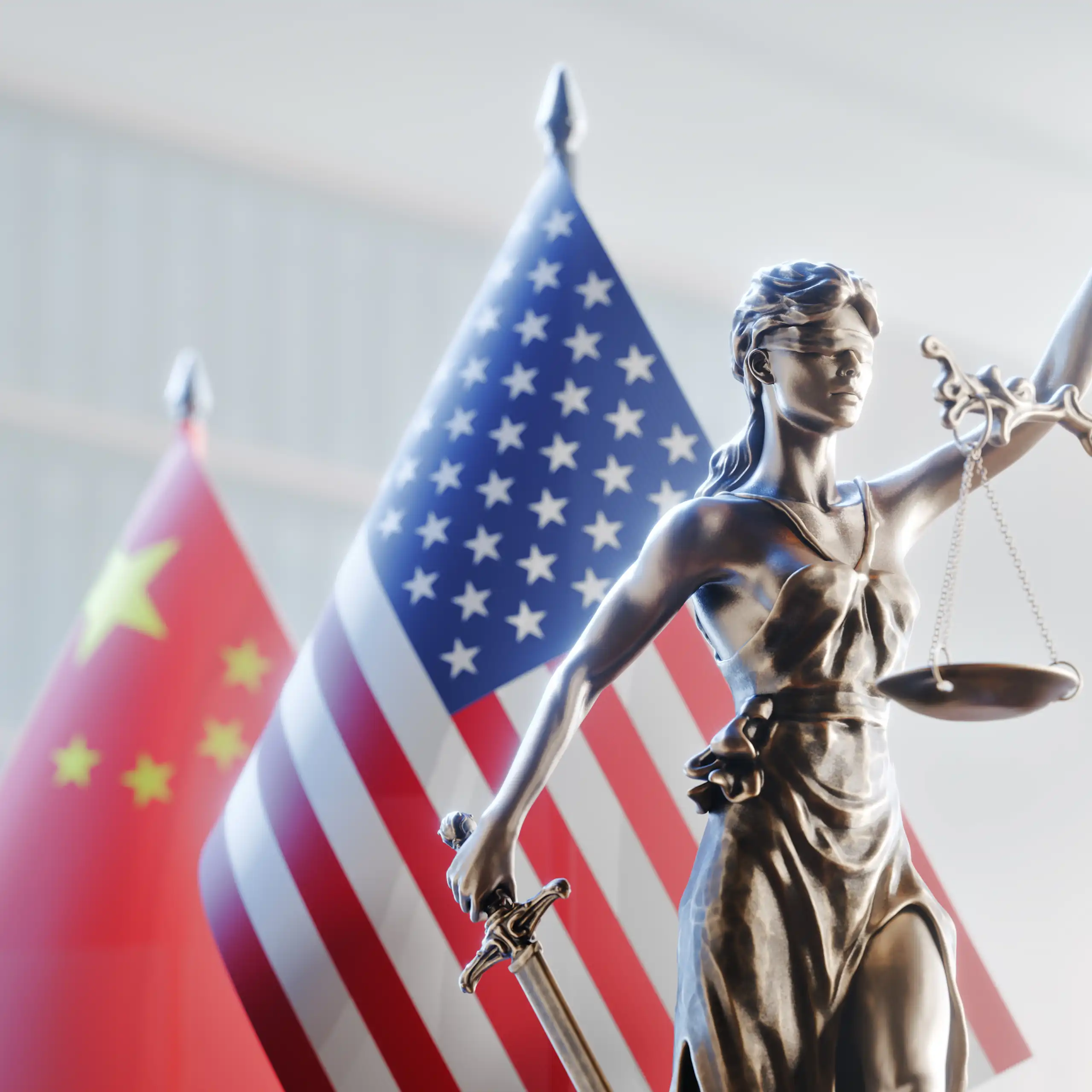 La Justice, aveugle, tenant sa balance à bout de bras avec, derrière elle, les drapeaux des États-Unis et de la Chine.