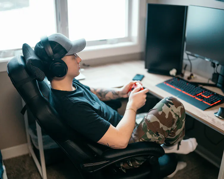 Un jeune homme joue à un jeu vidéo sur son ordinateur