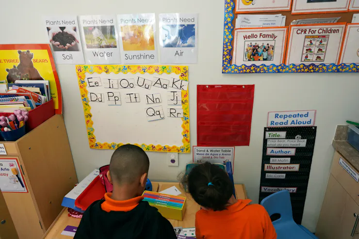 Very young children participate in a classroom activity.
