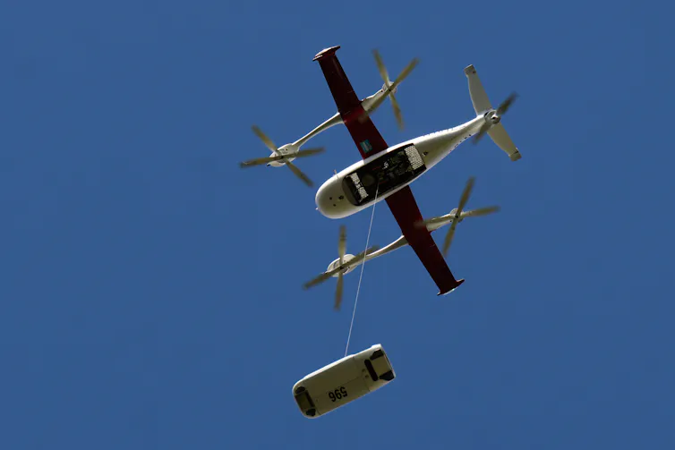 El uso de drones está a punto de crecer a medida que la FAA cambia las reglas para permitir a los pilotos volarlos fuera de la vista 1 una pequeña nave en el cielo con un objeto suspendido debajo por un cable
