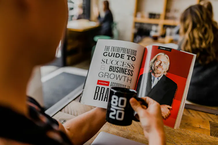 An over the shoulder shot of someone reading a book about entrepreneurial success