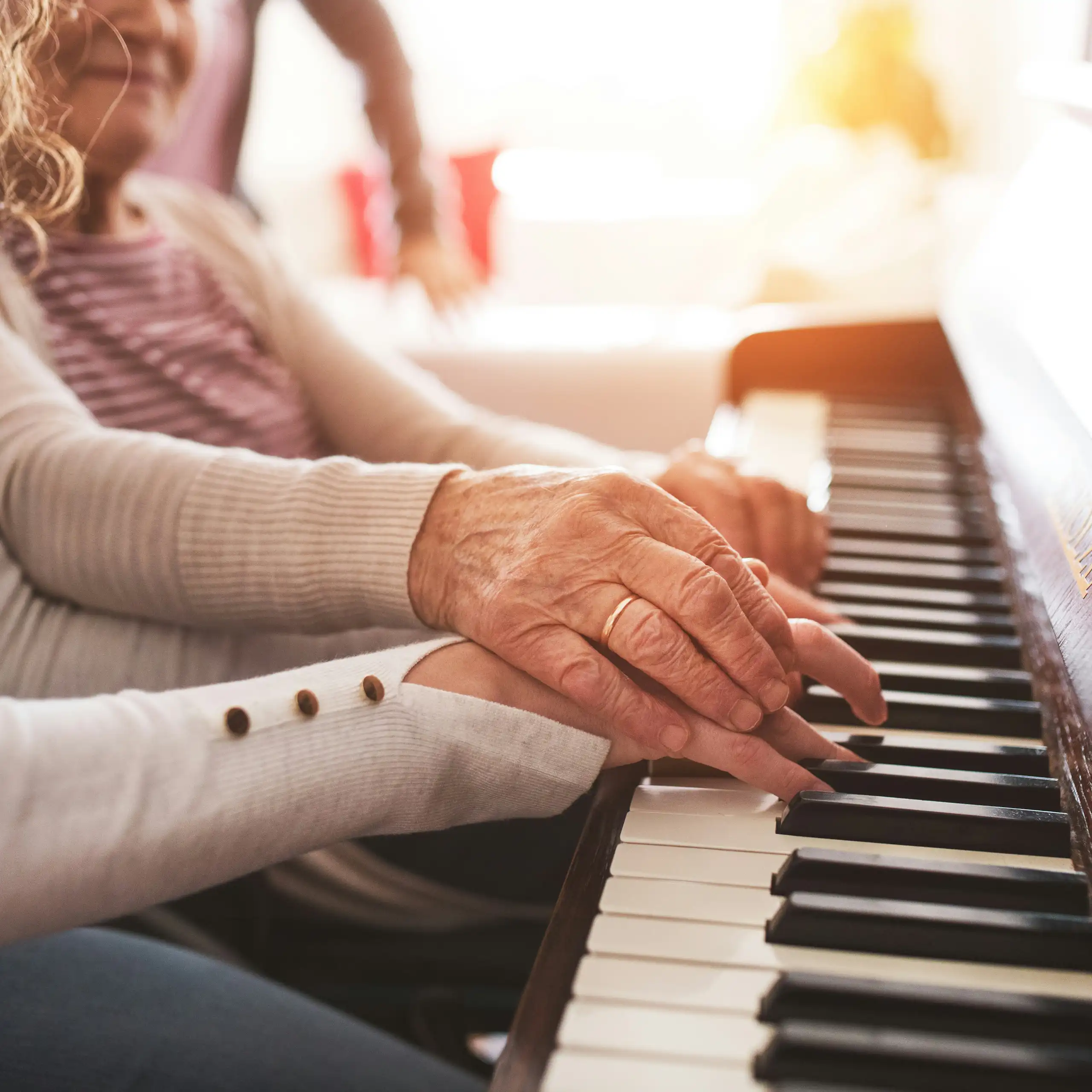 Photo of two sets of hands — one younger and one older — on a piano keyboard