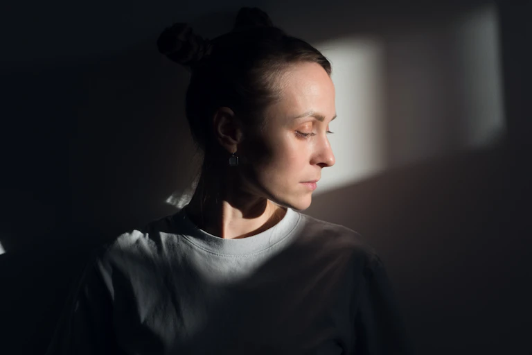 A woman in prison looks despondent