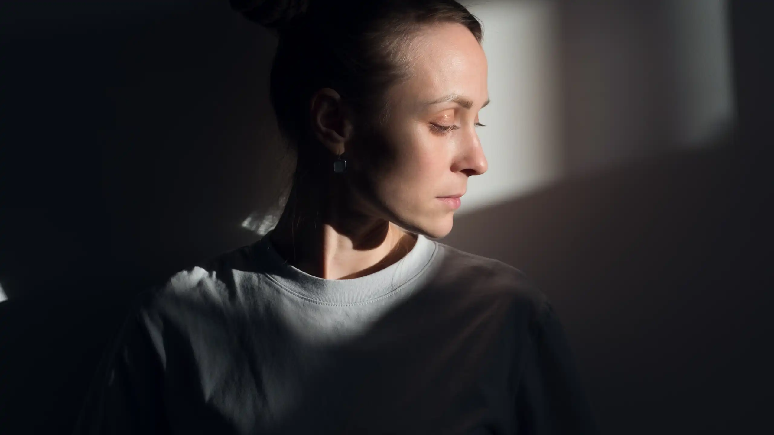 A woman in prison looks despondent