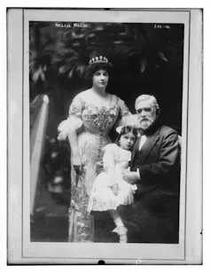An old photo with a women, a young girl and a man posing
