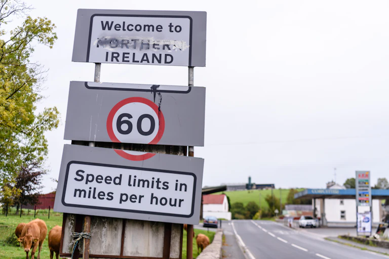 A road sign reading 'Welcome to Northern Ireland' where the word 'northern' has been scrubbed away or covered with white paint